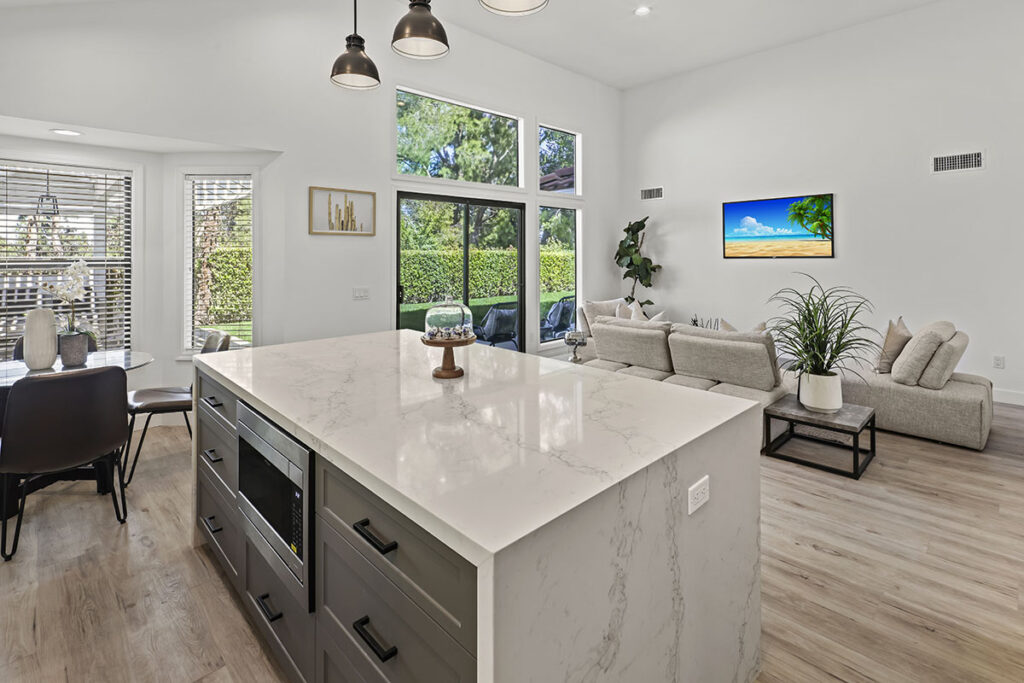High-end open-concept kitchen with marble waterfall island and custom cabinetry by ATA Custom Cabinets