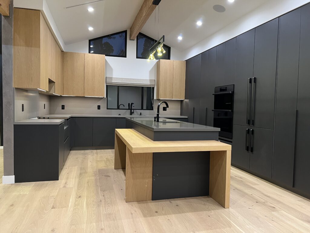White oak and matte black slab cabinets with a waterfall oak island in the Wells project kitchen by ATA Custom Cabinets